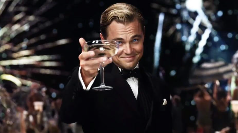 A photo of the actor Leonardo Dicaprio as Jay Gatsby holding up a celebratory glass of champagne